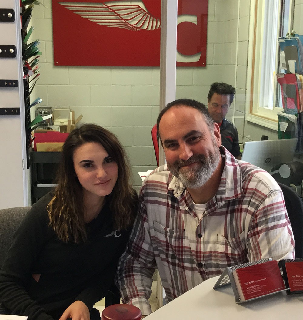 Center City Collision office A woman and man seated in the office of an auto body shop