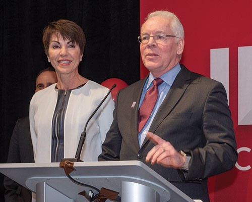 Portfolio 2018, Wendy and Drew Boyd Professor Drew Boyd speaking at a podium next to his wife Wendy