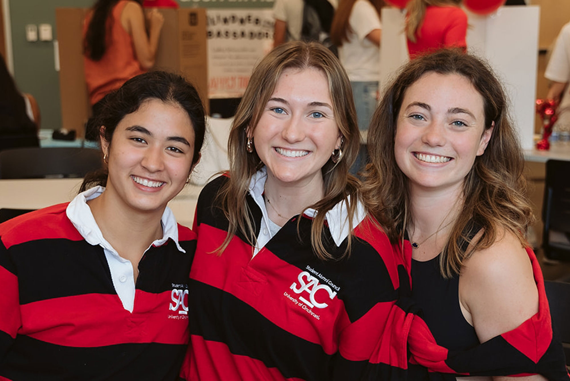 Three University of Cincinnati Business students share a smile at the First-Year Experience event